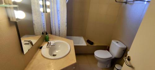 y baño con lavabo, aseo y bañera. en APARTAMENTO COVES NOVES, en Port d'Addaia