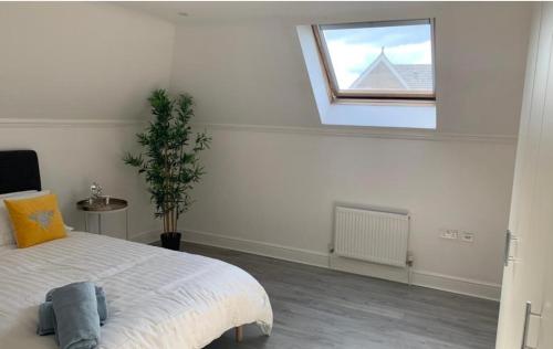 a white bedroom with a bed and a window at Addlestone - Large Stunning 2 bed room Apartment in Addlestone