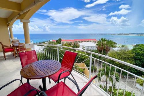 d'un balcon avec une table et des chaises donnant sur l'océan. dans l'établissement Villa Sea Forever @ Pelican Key - Paradise Awaits!, à Simpson Bay