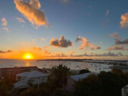 een zonsondergang boven een haven met boten in het water bij Villa Sea Forever @ Pelican Key - Paradise Awaits! in Simpson Bay