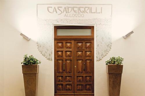 a sign above a door with two potted plants at B&B Casa Dei Grilli in Longiano