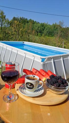 a tray of fruit and a cup of wine on a table at Vikendica za odmor in Banja Luka
