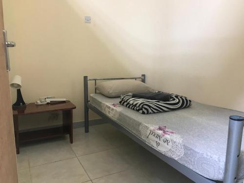 a small bedroom with a bed and a table at Backpacker's Bed - Central Bus Terminal in Abu Dhabi