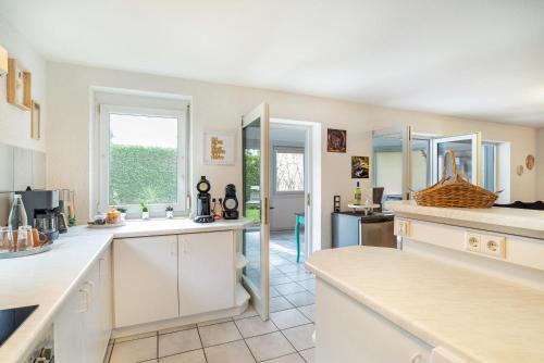 a kitchen with white cabinets and a large window at Bei s' Herrs in Rheinmunster