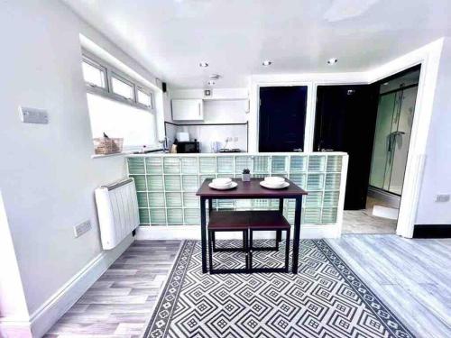 a kitchen with a table in the middle of a room at Studio Apartment in London in London