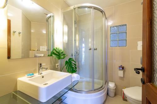 een badkamer met een wastafel en een douche bij Villa OZ in Kalkan