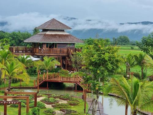 un grand bâtiment avec un pont sur une rivière dans l'établissement แลภู ดูนา LaePhu DooNa Resort and Restaurant, à Ban San Pa Sak