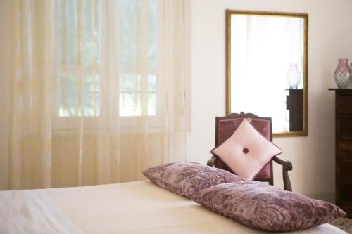 a pillow sitting on top of a bed with a window at B&B Casa Dei Grilli in Longiano