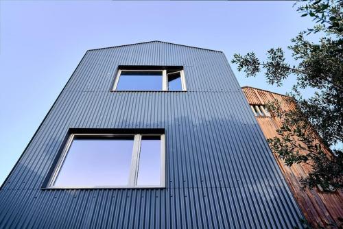a tall building with two windows on the side of it at Fabrica No Jardim in Porto