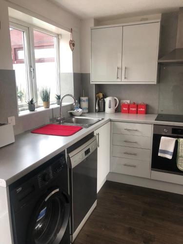a kitchen with a washing machine and a sink at Homely property close to Princess Royal hospital and Apley Wood in Wellington