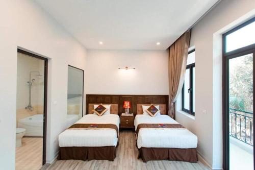 Habitación con 2 camas y baño con bañera. en GRAD Korea Hotel 2, en Làng Thành