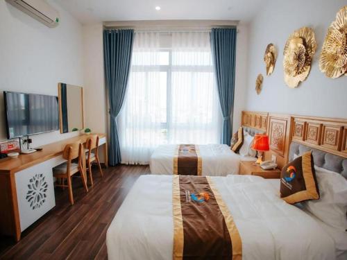 ein Hotelzimmer mit 2 Betten und einem Schreibtisch in der Unterkunft GRAD Korea Hotel 2 in Làng Thành