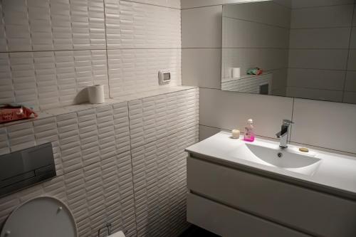 a bathroom with a sink and a toilet and a mirror at דירת 5 חדרים בבניין הכי טוב בעיר עם נוף מרהיב לים in Ashdod