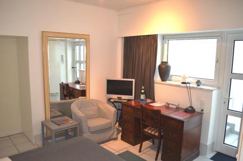 a living room with a desk with a computer and a chair at AV No.1 in Düsseldorf