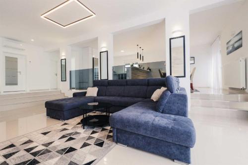 - un salon avec un canapé bleu et des chaises dans l'établissement Villa Miranda with pool, à Zaton