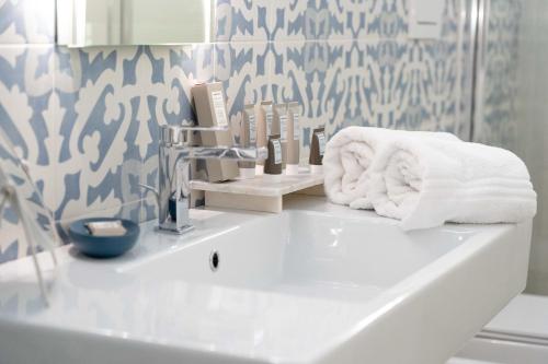 łazienka z umywalką i ręcznikami w obiekcie Le tre rondini w mieście Barletta