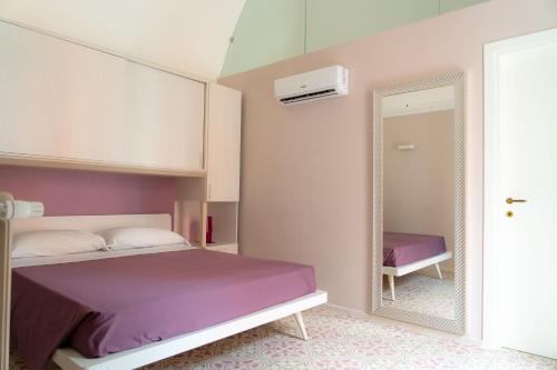 sypialnia z łóżkiem i lustrem w obiekcie Le tre rondini w mieście Barletta