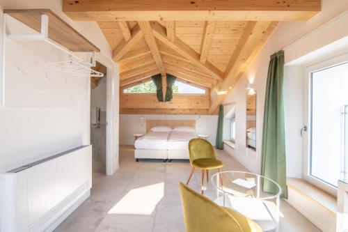 een slaapkamer met een bed en een tafel en stoelen bij R&B al lago in Domaso