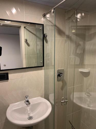 a bathroom with a sink and a glass shower at Hotel Urban Center Bogota in Bogotá