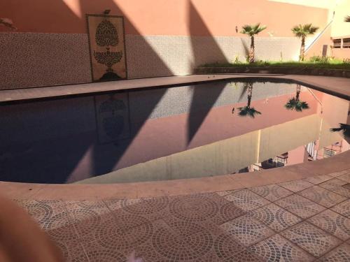 un reflet d'une piscine dans un bâtiment dans l'établissement Belle Vue, à Marrakech