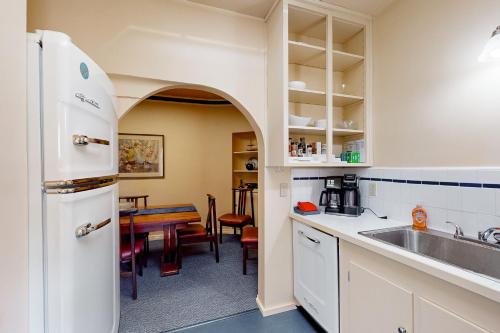 a kitchen with a white refrigerator and a table at Eureka Theatre Apartment in Eureka