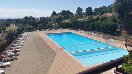 a large swimming pool with lounge chairs at "L'Horizon Bleu" Vue mer - 2 chambres - Parking - Piscine in La Croix-Valmer