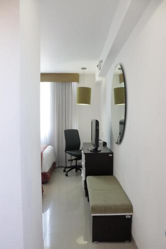 a hotel room with a desk and a bed and a mirror at Hotel México Plaza Irapuato in Irapuato