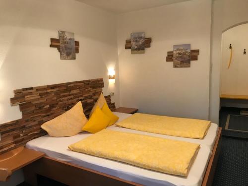 two beds in a hotel room with yellow pillows at Haus Hoher Sattel in Leutasch