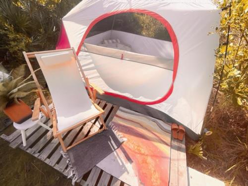 a chair and a boat in a tent at eco-dome off-grid garden glamping in Bithlo