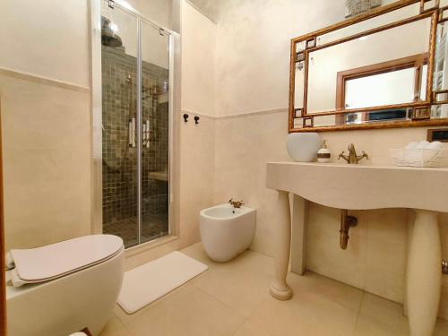 a bathroom with a toilet and a sink and a shower at Villa Asia in Viagrande