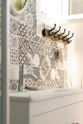 La salle de bains est pourvue d'un lavabo et d'un mur en carrelage. dans l'établissement la marronière, à Brignoles