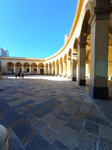 a large building with arches and a stone courtyard at Casale Sammartano Apartments in Ummari
