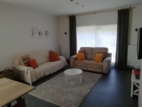 a living room with two couches and a table at Huis Ter Duin in Koksijde
