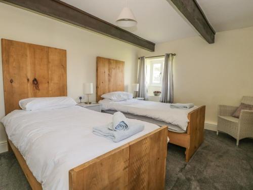 a bedroom with two beds and a chair at The Hayloft in Ripon