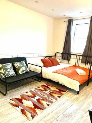 a bedroom with a bed and a rug at Spacious Studio flat in Central London in London