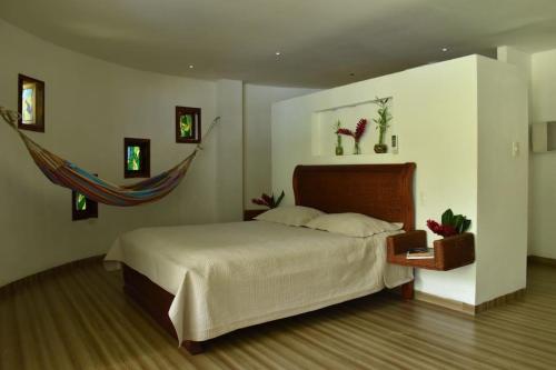 Un dormitorio con una cama y una hamaca. en Malía Casa Campo, en Santa Marta