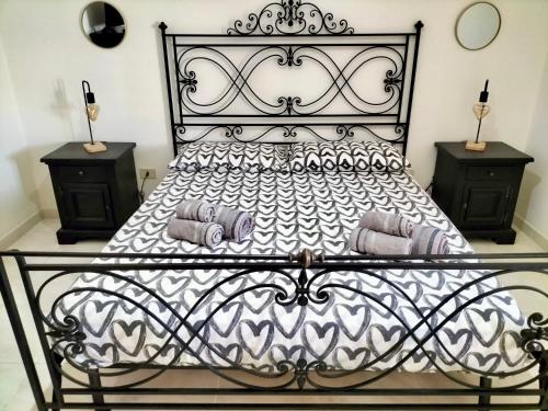 a bedroom with a black and white bed with two night stands at Belvedere House Holiday Siracusa Ortigia in Belvedere