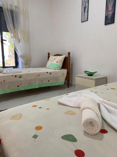 a bedroom with two beds and a bedspread with flowers on it at Villa Meta - Welcoming You with Byrek & Traditional Meals in Gusmar