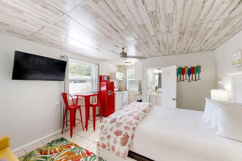 1 dormitorio con 1 cama y cocina con armarios rojos en Citrus Room, en Marathon