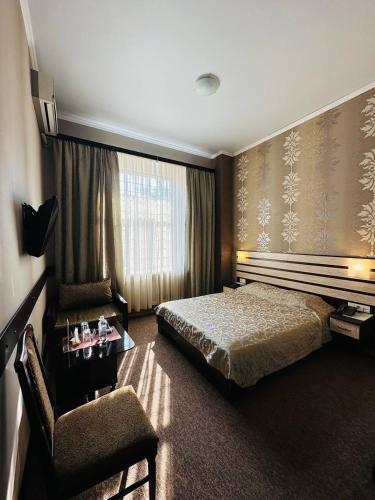 ein Hotelzimmer mit einem Bett und einem Stuhl in der Unterkunft Classic Hotel in Kharkov
