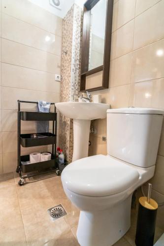 a bathroom with a white toilet and a sink at Joanna Luxury Apartment in Preveza
