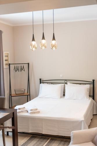 a bedroom with a bed with white sheets and lights at Joanna Luxury Apartment in Preveza