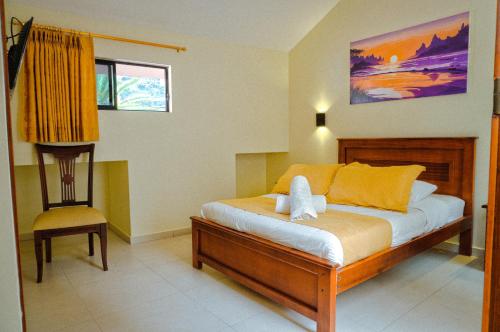 una camera con letto e sedia di Hostal CañaLimeña a Baños