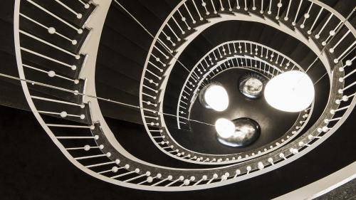 a spiral staircase in a building with lights at Holiday Inn Dresden - Am Zwinger by IHG in Dresden