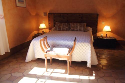 a bedroom with a bed with a chair and two lamps at Posada de la Triste Condesa in Arenas de San Pedro