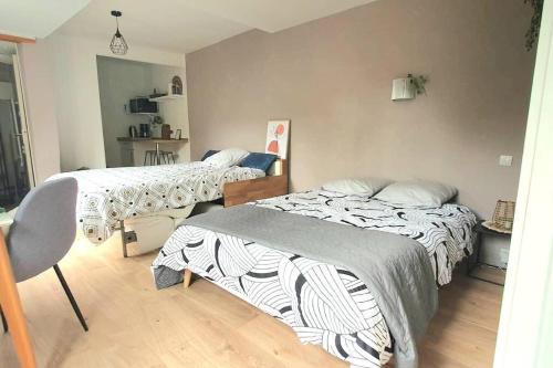 - une chambre avec 2 lits et une chaise dans l'établissement studio cosy 1er centre Laval vu château et jardin, à Laval