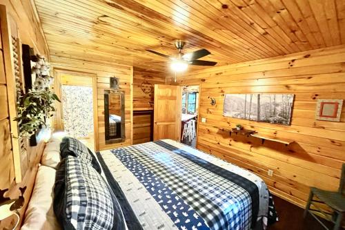 ein Schlafzimmer mit einem Bett in einer Holzhütte in der Unterkunft Coffee Creek Cabin in Sautee Nacoochee