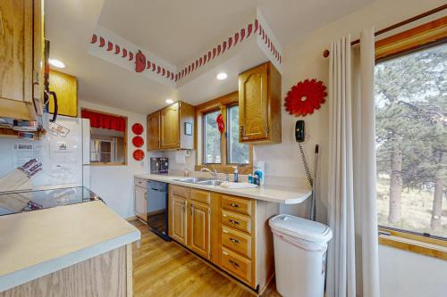 cocina con armarios de madera, fregadero y ventana en Deer Mountain Lodge South, en Estes Park