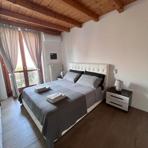 a bedroom with a large bed and a large window at VILLA LIDO - Lake Como in Colico