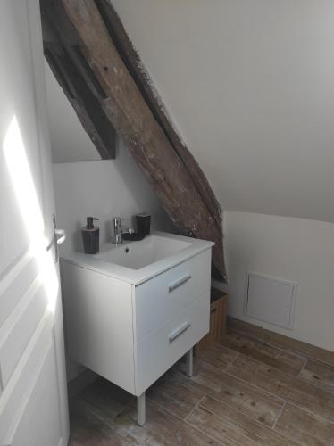 ein Badezimmer mit einem weißen Waschbecken im Dachgeschoss in der Unterkunft gites de terophey & kena in Thiberville